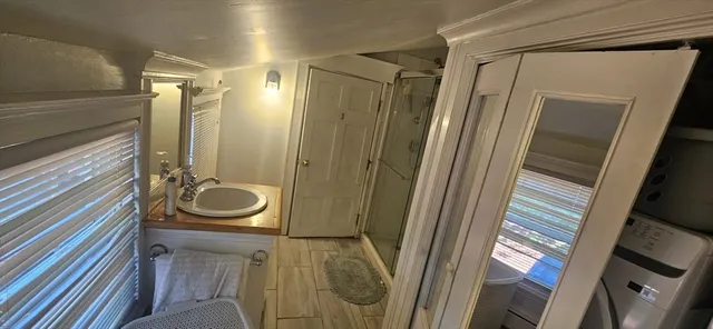 a bathroom with a sink a mirror and shower