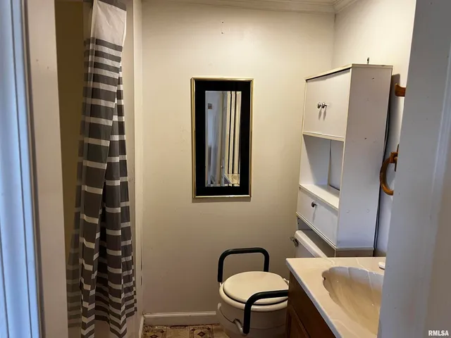 a bathroom with a toilet a sink and mirror