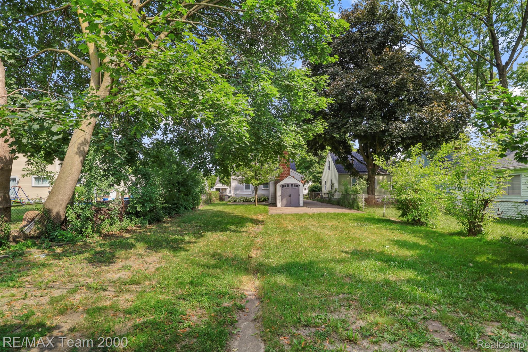 3130 Chestnut Street Dearborn, MI 48124 - Photo 6 of 30 Expansive green space featuring mature trees and a detached garage with a light gray facade