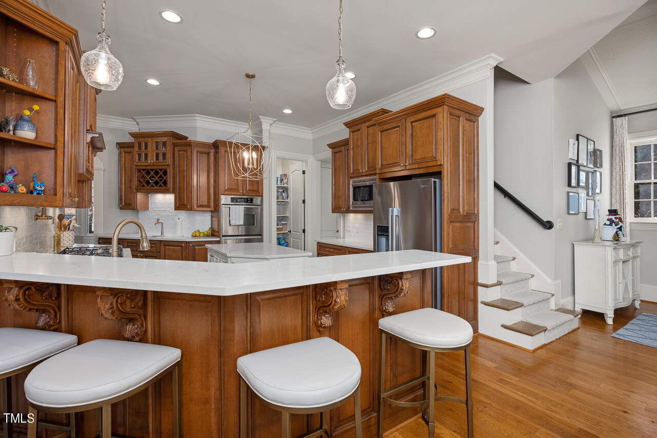 1204 High Glen Point Raleigh, NC 27614 - Photo 16 of 73 a kitchen with stainless steel appliances a table chairs and a refrigerator