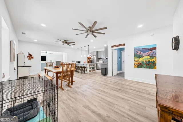 a kitchen with stainless steel appliances kitchen island granite countertop a table chairs sink and cabinets