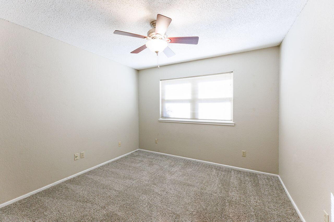 3409 84th Street Lubbock, TX 79423 - Photo 18 of 25 an empty room with a window and a fan