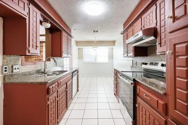 a kitchen with stainless steel appliances granite countertop a sink stove and cabinets