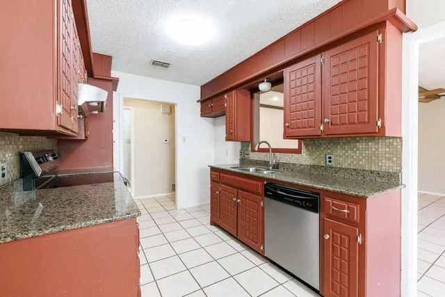 a kitchen with stainless steel appliances granite countertop a stove a sink and a microwave