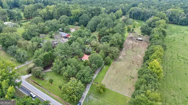 an aerial view of residential house with outdoor space and trees all around