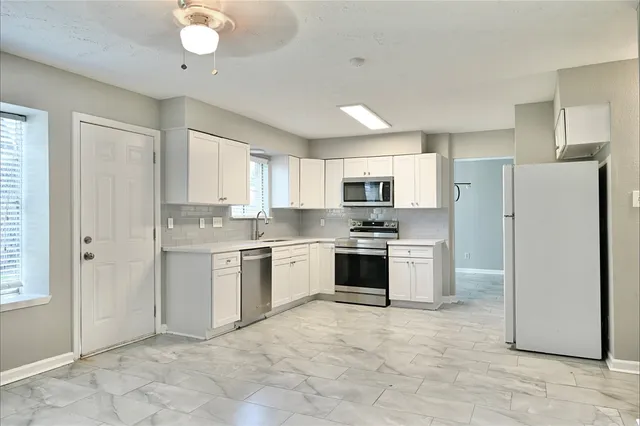 a kitchen with refrigerator cabinets and a sink