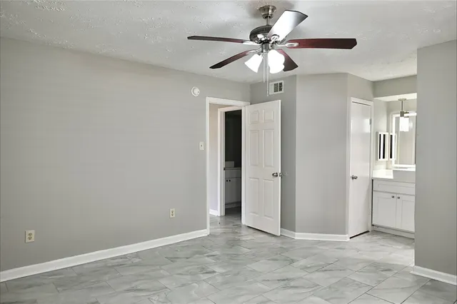 an empty room with fan and a ceiling fan