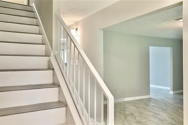 a view of staircase with wooden floor and white walls