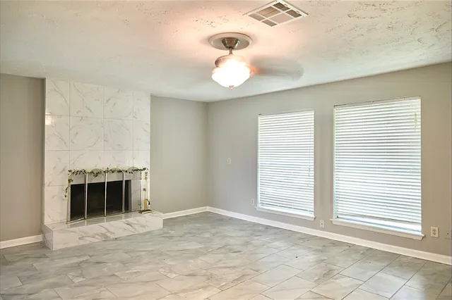 a view of an empty room with a window and fireplace