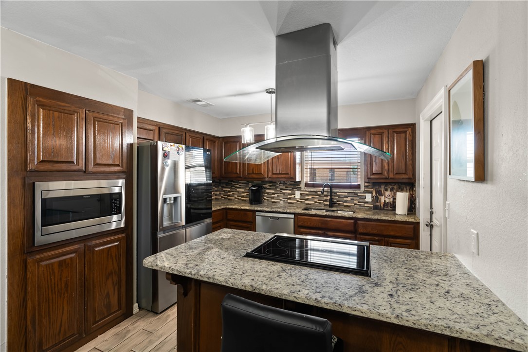 985 Ribbontail Street Corpus Christi, TX 78418 - Photo 6 of 15 a kitchen with stainless steel appliances granite countertop a refrigerator a stove and a sink