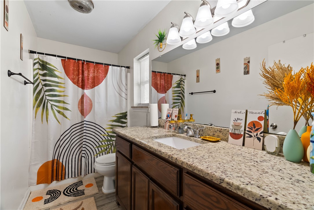 985 Ribbontail Street Corpus Christi, TX 78418 - Photo 10 of 15 a bedroom with a bed and a chandelier