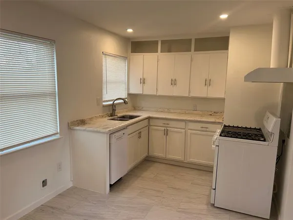a kitchen with granite countertop white cabinets and white appliances