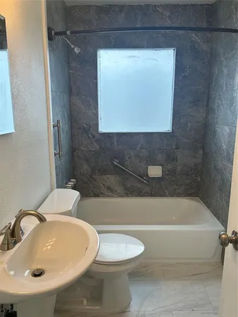 a bathroom with a sink a toilet and bathtub
