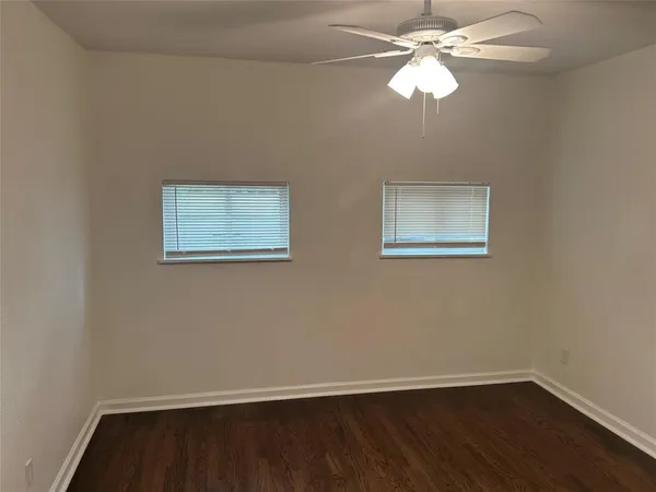 a view of a room with wooden floor closet and a ceiling fan