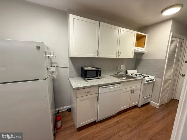 a kitchen with a refrigerator sink and cabinets