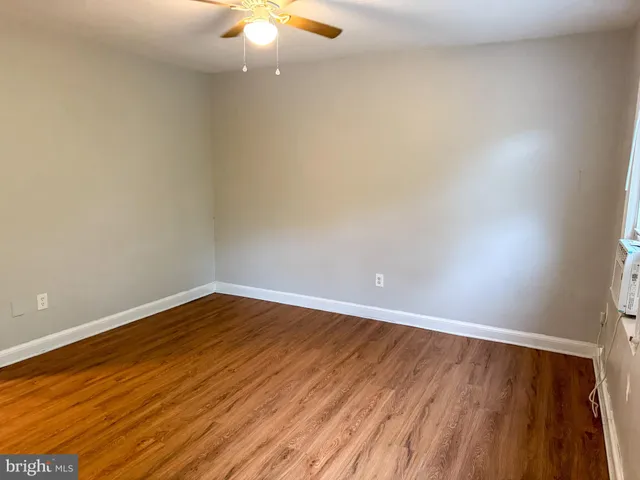a view of an empty room with wooden floor