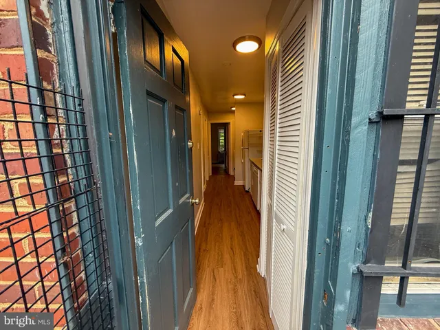 a view of a hallway with a glass door and furniture