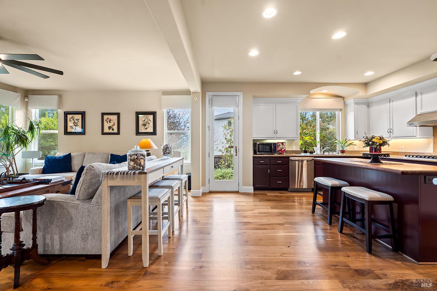 3696 Newbury Court Santa Rosa, CA 95404 - Photo 11 of 52 a open kitchen with granite countertop a refrigerator a stove a dining table and chairs with wooden floor