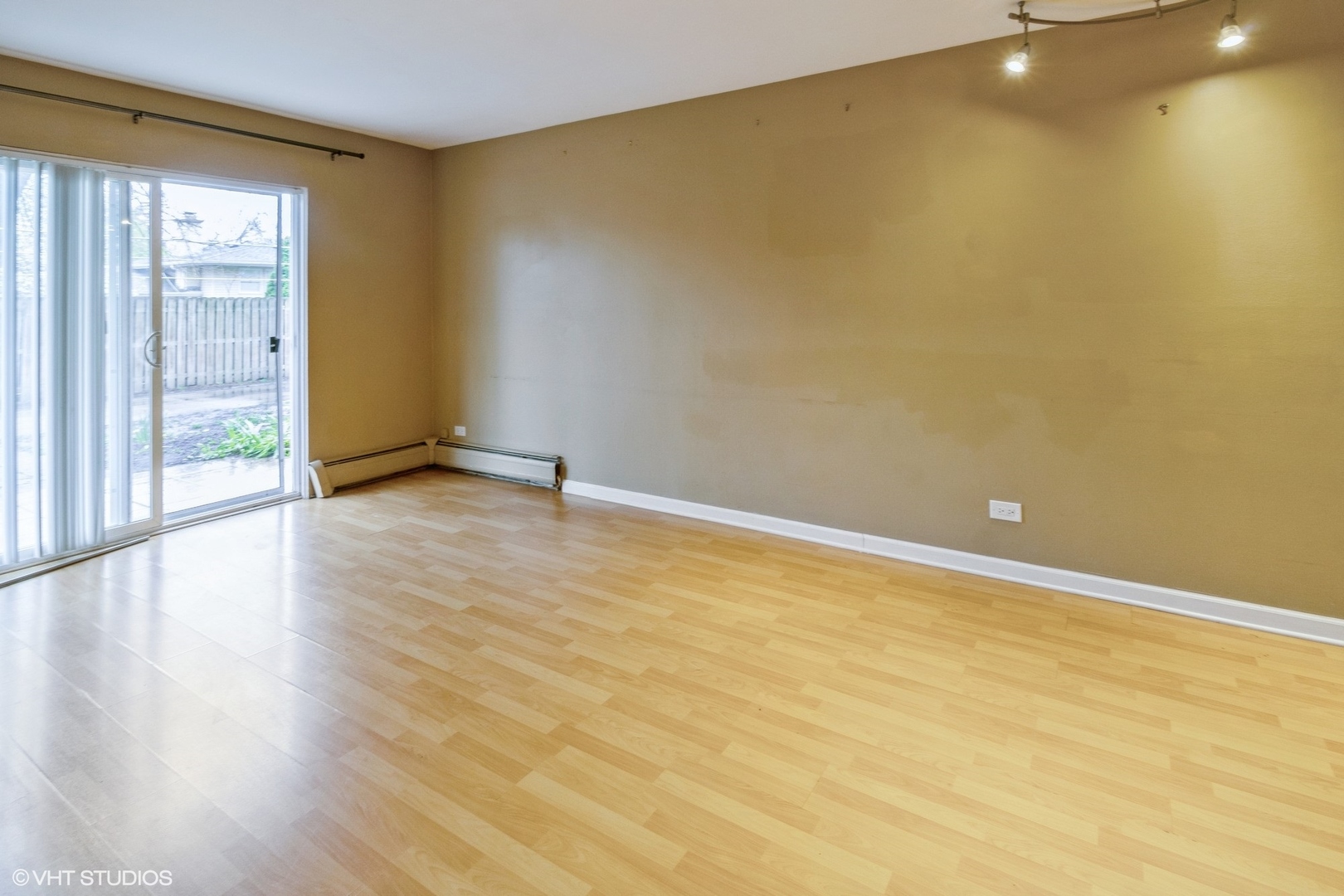 2323 South Goebbert Road, Unit 109 Arlington Heights, IL 60005 - Photo 4 of 11 a view of an empty room with wooden floor and a window