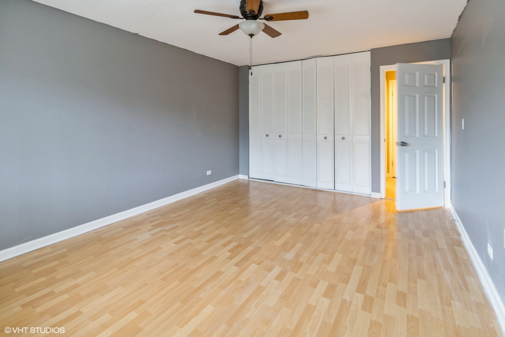 2323 South Goebbert Road, Unit 109 Arlington Heights, IL 60005 - Photo 6 of 11 a view of empty room with wooden floor and fan