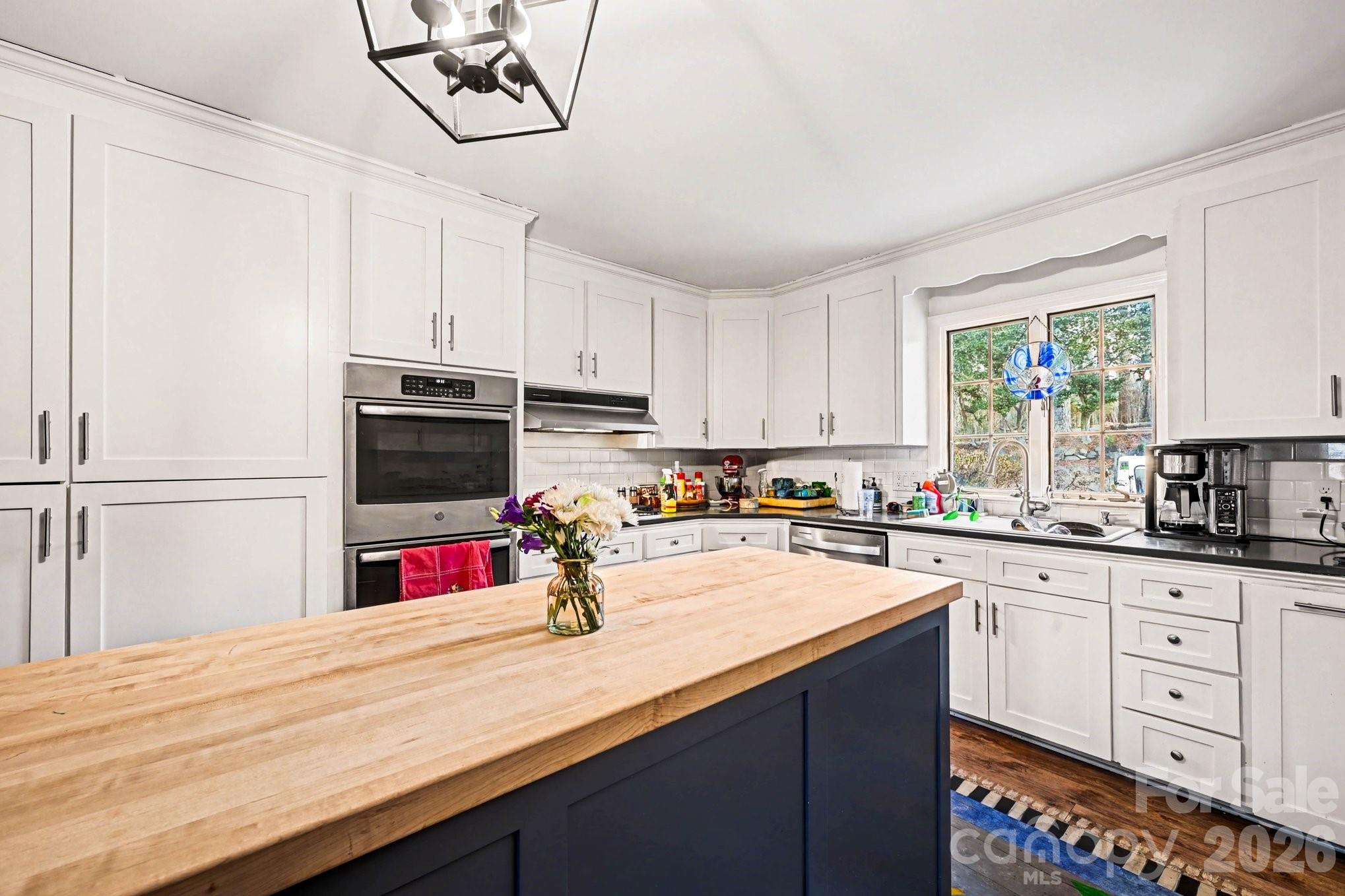 2915 Old Stage Road Gastonia, NC 28052 - Photo 22 of 42 a kitchen with white cabinets a sink dishwasher and a stove with wooden floor
