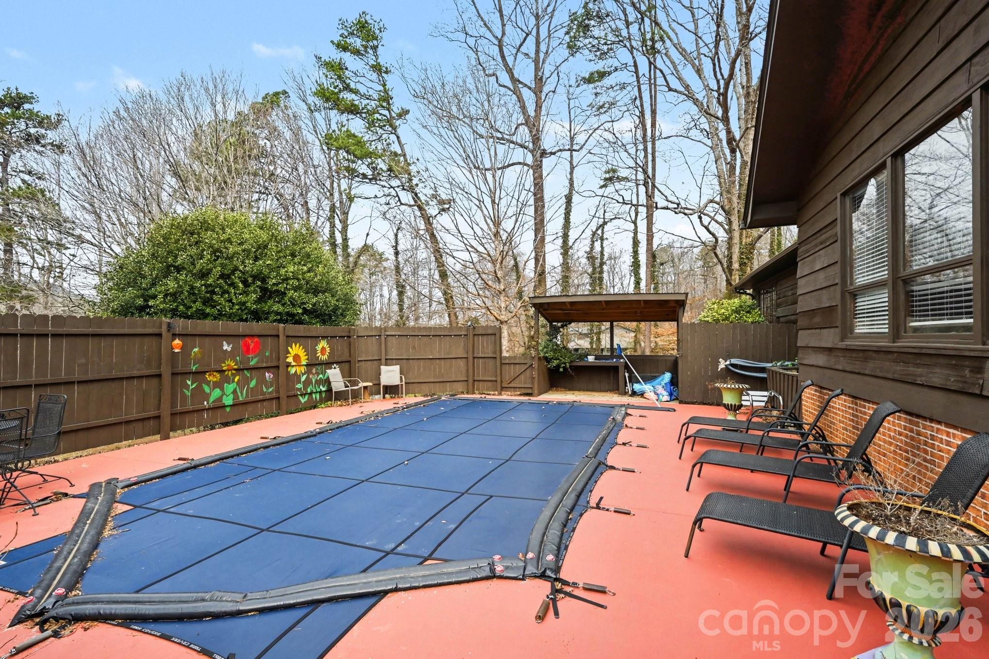 2915 Old Stage Road Gastonia, NC 28052 - Photo 32 of 42 a view of a patio with couches table and chairs under an umbrella with wooden fence