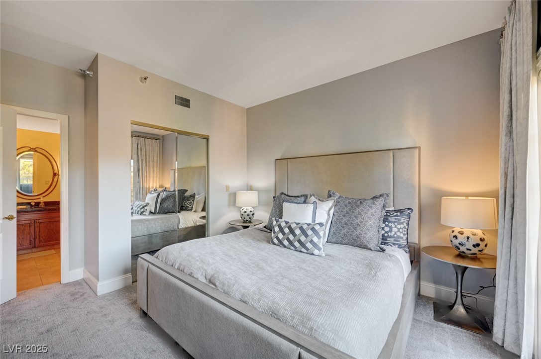 30 Strada Di Villaggio, Unit 250 Henderson, NV 89011 - Photo 16 of 52 Bedroom featuring light carpet, a closet, and ensuite bathroom