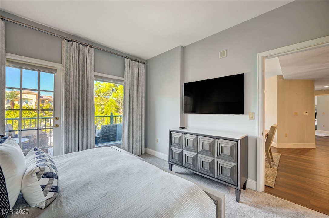 30 Strada Di Villaggio, Unit 250 Henderson, NV 89011 - Photo 18 of 52 Bedroom featuring access to outside, light carpet, and light wood-type flooring