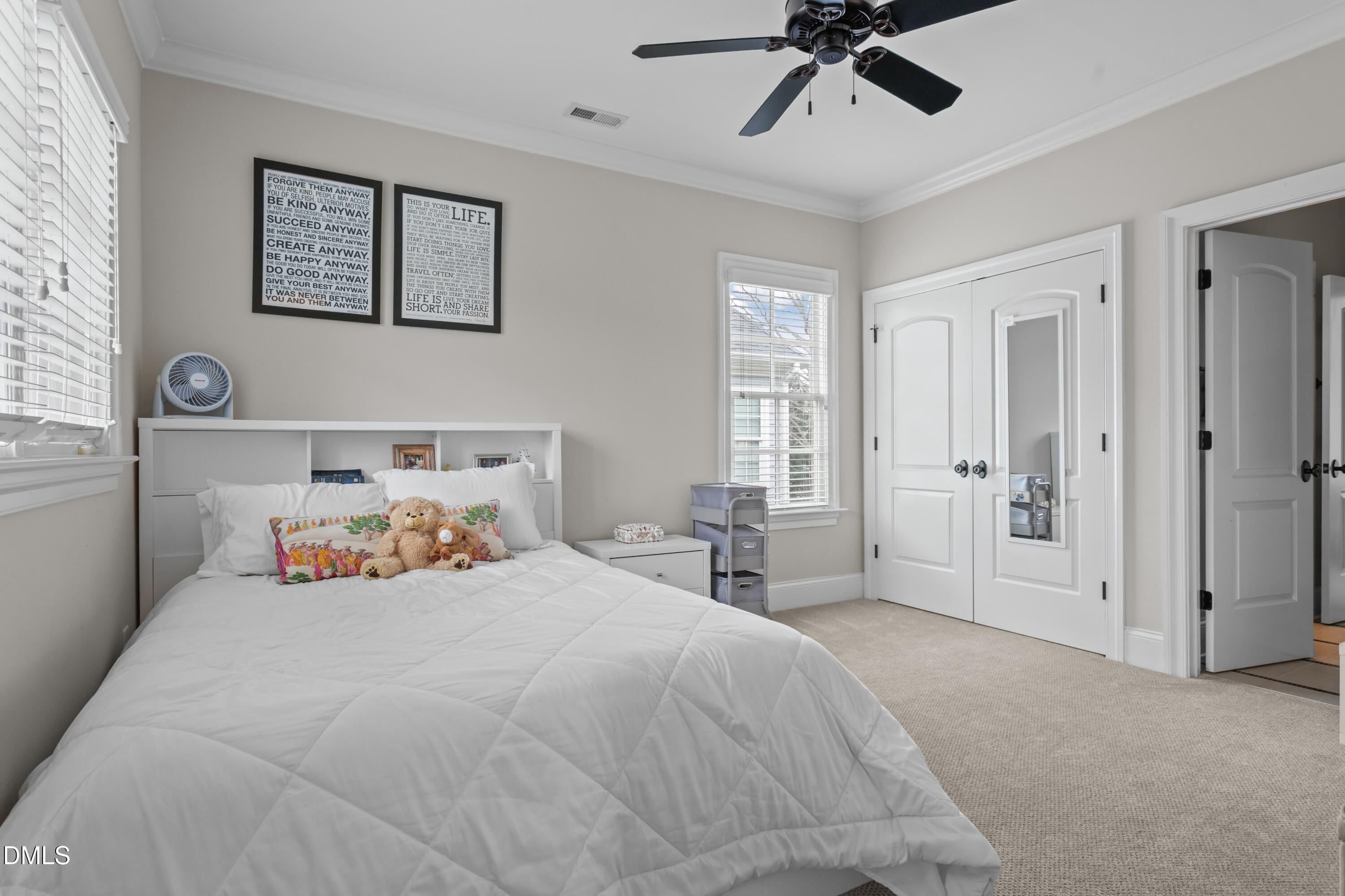 514 Wayne Drive Raleigh, NC 27608 - Photo 24 of 53 a bedroom with a bed and a chandelier