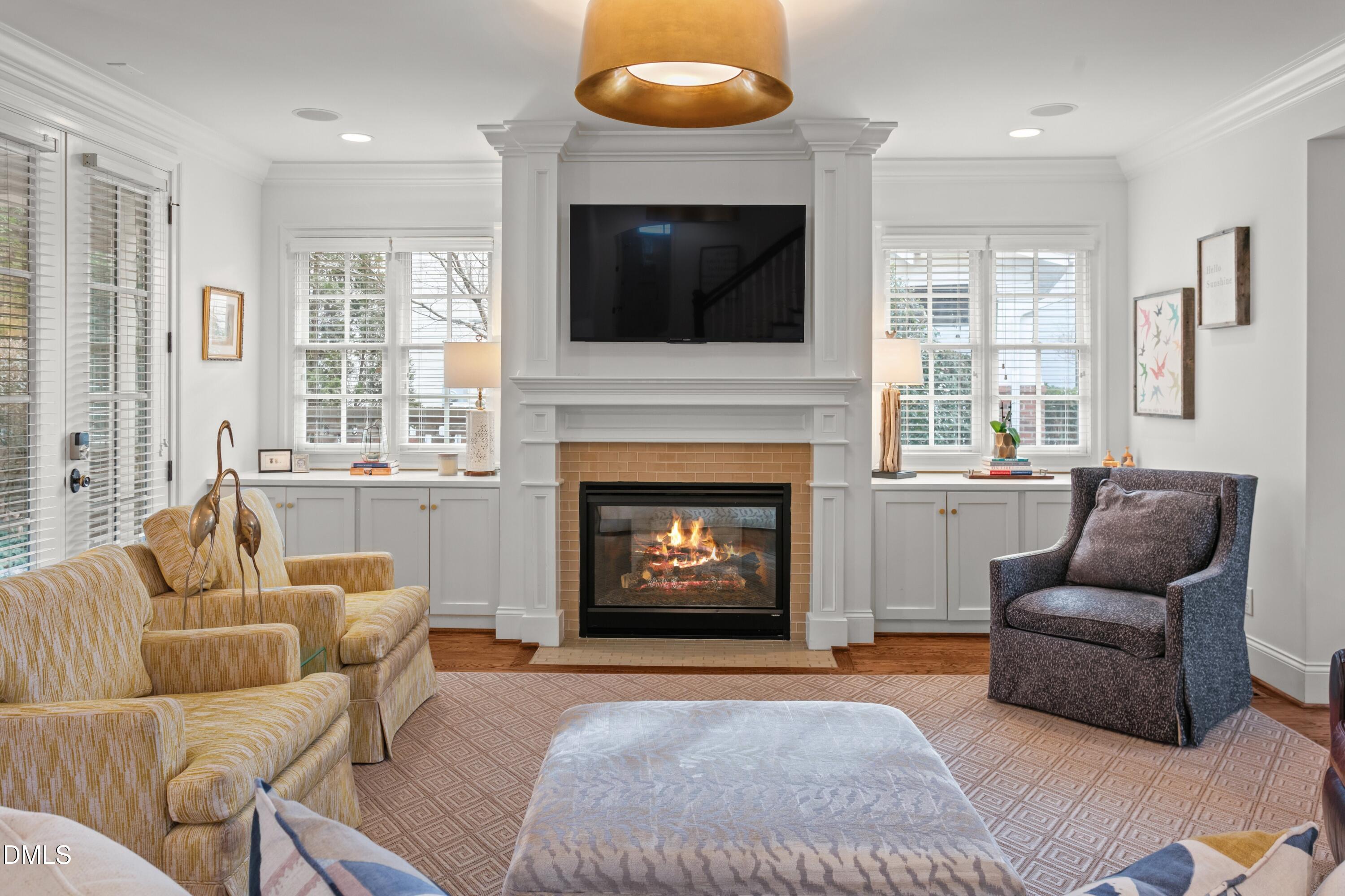 514 Wayne Drive Raleigh, NC 27608 - Photo 7 of 53 a living room with furniture a flat screen tv and a fireplace