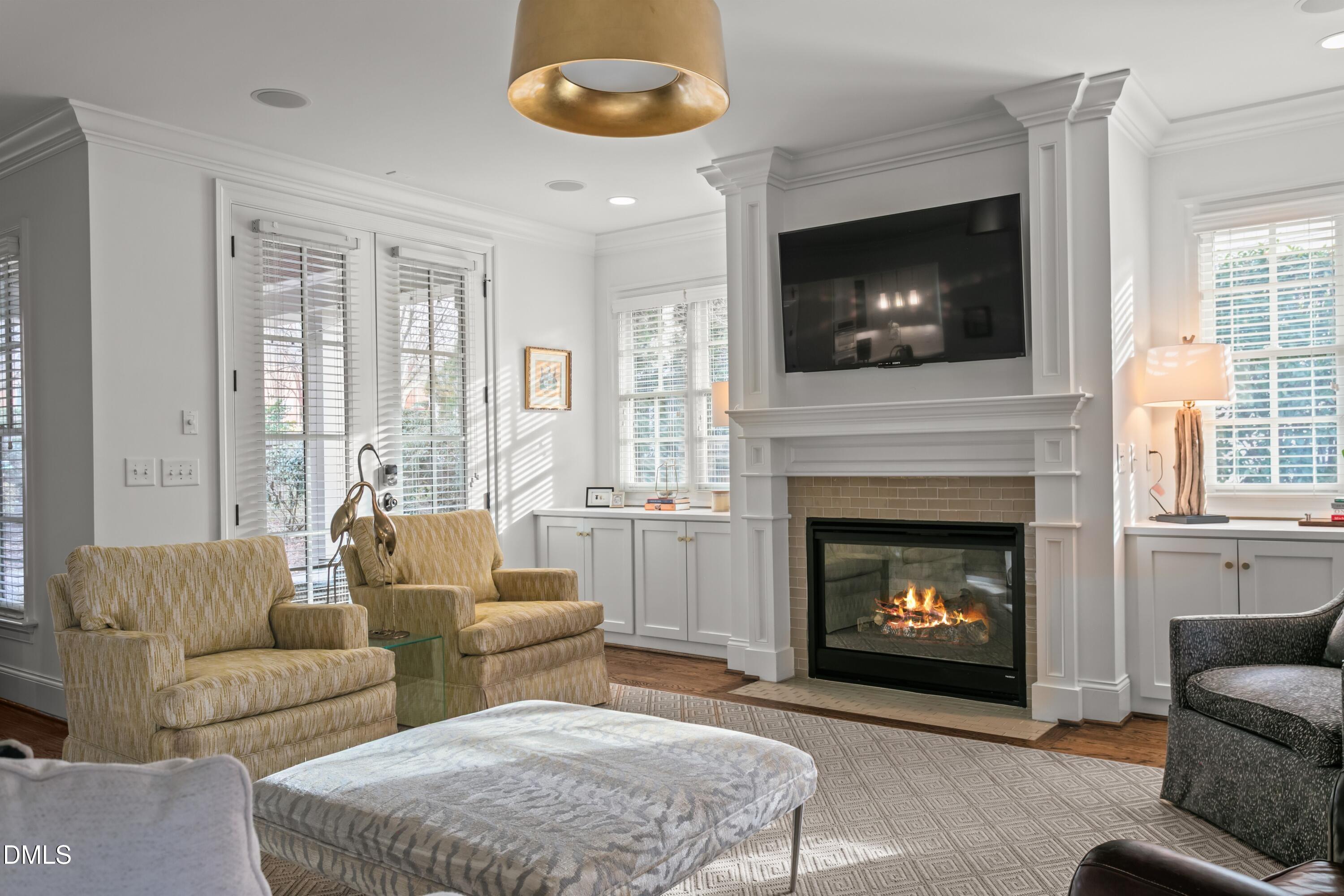 514 Wayne Drive Raleigh, NC 27608 - Photo 8 of 53 a living room with furniture a flat screen tv and a fireplace