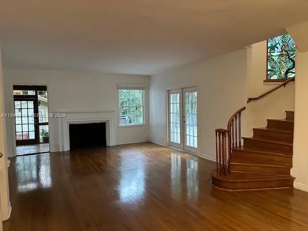 a view of an entryway with wooden floor and a fireplace