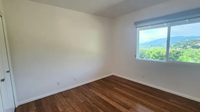 a view of a small space with wooden floor and a window