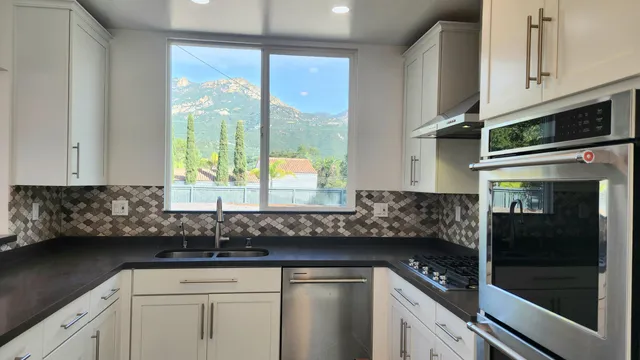 a kitchen with stainless steel appliances granite countertop a sink a stove and a microwave