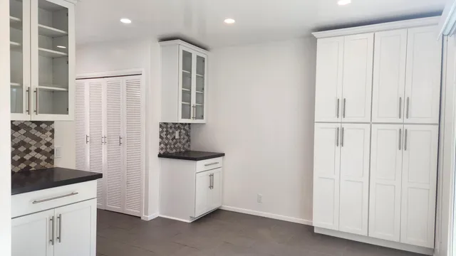 a kitchen with white cabinets and white appliances