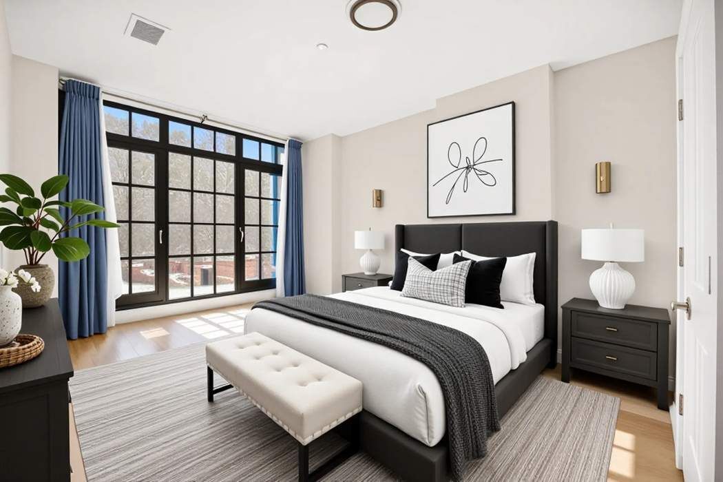 37-24 30th Street, Unit 2F Queens, NY 11101 - Photo 11 of 12 a bedroom with a bed and a large window