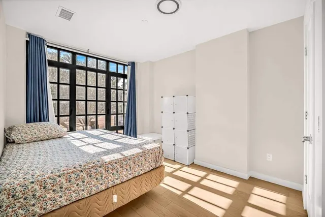 a bedroom with a bed and a large window