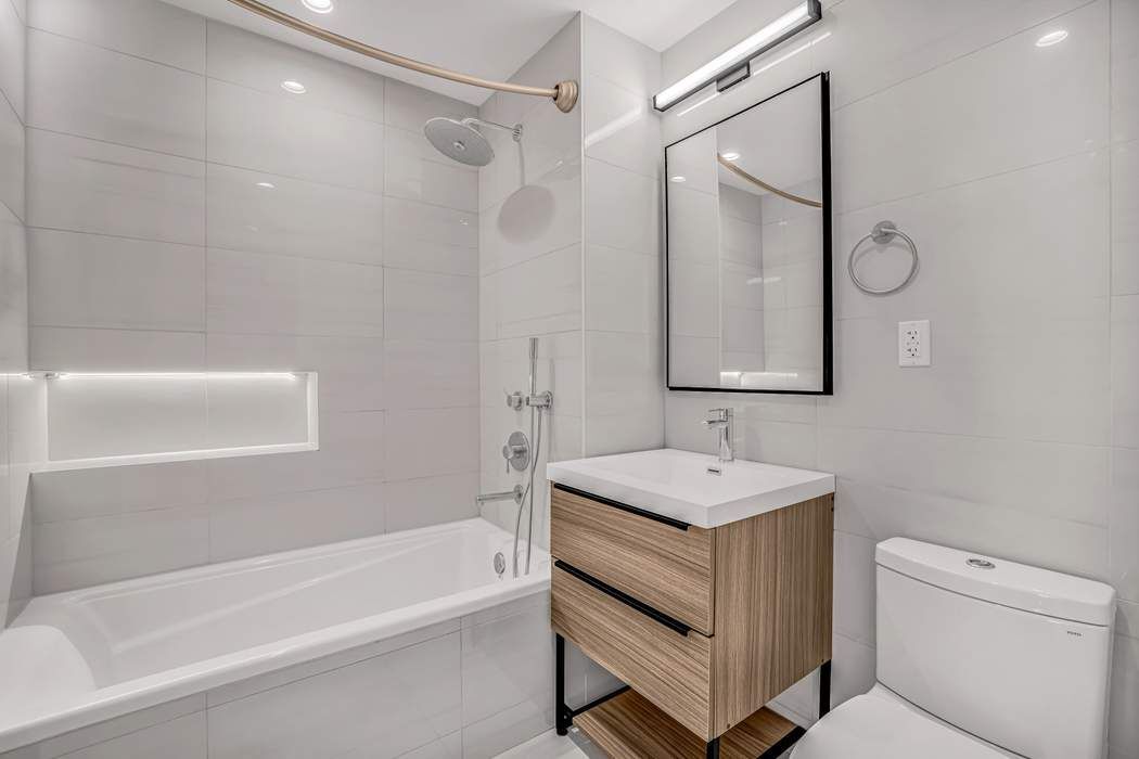 37-24 30th Street, Unit 2F Queens, NY 11101 - Photo 7 of 12 a bathroom with a sink a toilet and bathtub