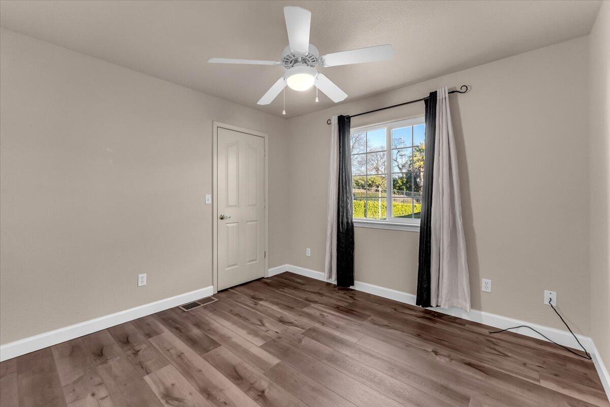 775 Stonebriar Trail Redding, CA 96003 - Photo 21 of 42 a view of an empty room with window and wooden floor