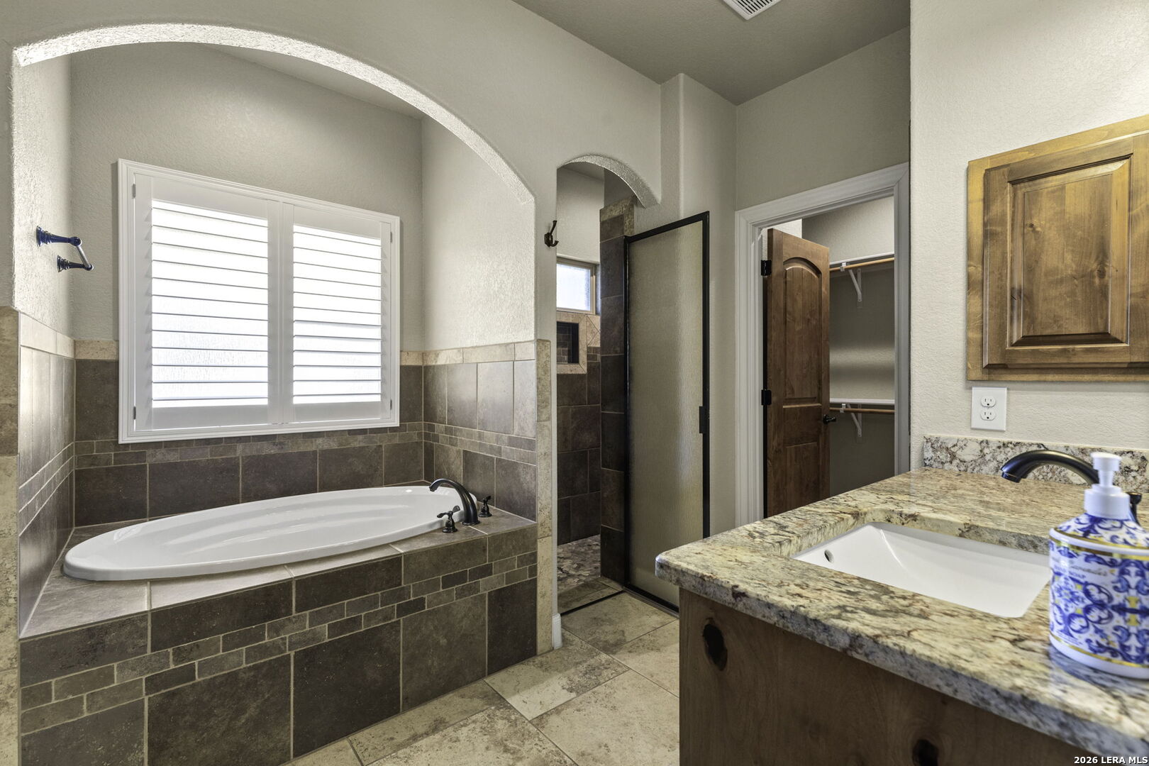 520 Arbor View Adkins, TX 78101 - Photo 18 of 32 a spacious bathroom with a granite countertop sink and a bathtub