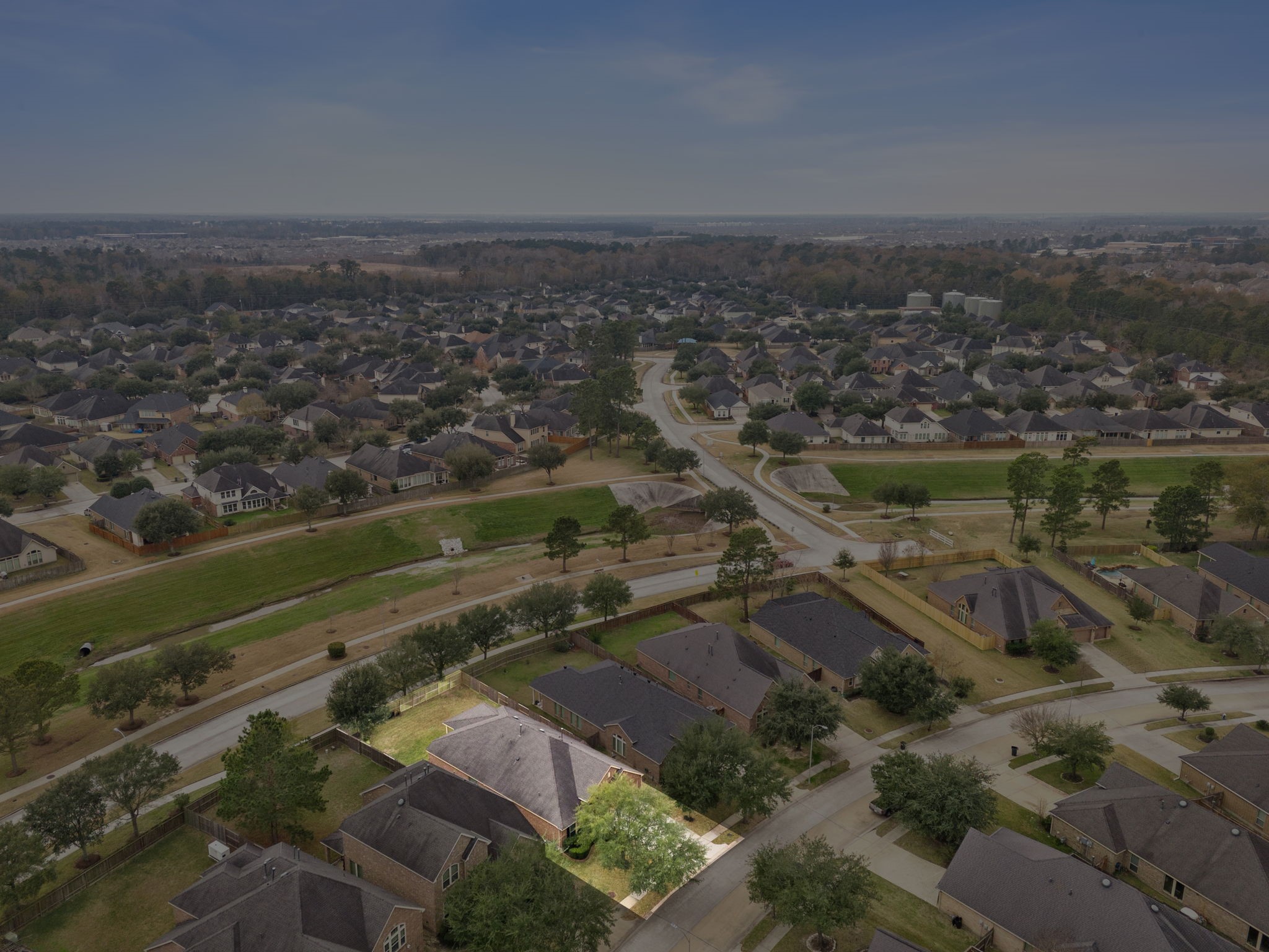 13014 Barkley Bend Lane Houston, TX 77044 - Photo 39 of 42 Aerial view highlights 13014 Barkley Bend Ln within the vibrant Lakeshore community, emphasizing its prime position on a picturesque street. This one-story brick home sits on an expansive lot with established trees and high curb appeal, offering long-term value near Lake Houston. Residents enjoy a quick commute to Downtown and access to neighborhood amenities including a clubhouse, fitness center, and pool.