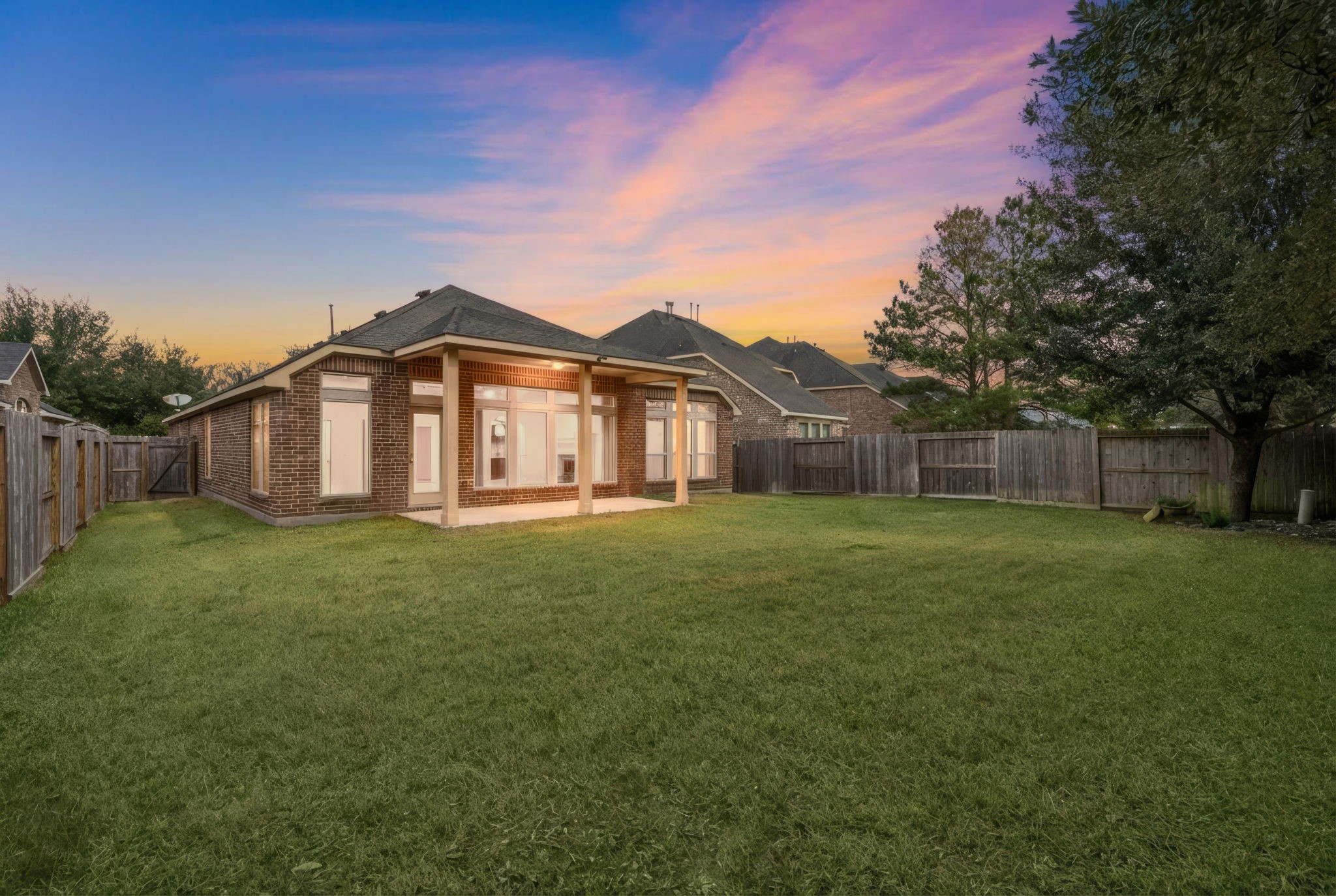 13014 Barkley Bend Lane Houston, TX 77044 - Photo 5 of 42 Expansive and private, the grassy backyard features a covered brick patio and ample space for outdoor activities within the sturdy wood fence. Large windows along the rear elevation ensure a seamless connection between the interior living spaces and this serene outdoor retreat.