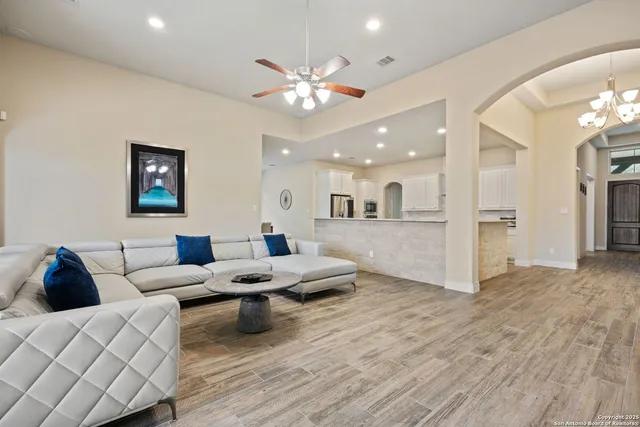 a living room with furniture and a view of kitchen