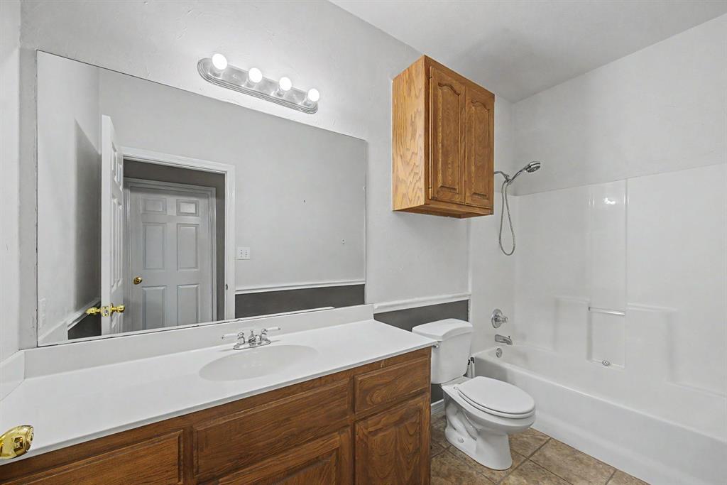 483 Christy Kay Lane Rhome, TX 76078 - Photo 16 of 40 a bathroom with a sink toilet a mirror and bathtub