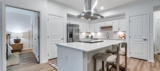 a kitchen with kitchen island granite countertop a sink cabinets and wooden floor