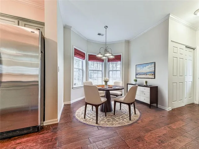 a dining room with wooden floor a chandelier a wooden table and chairs