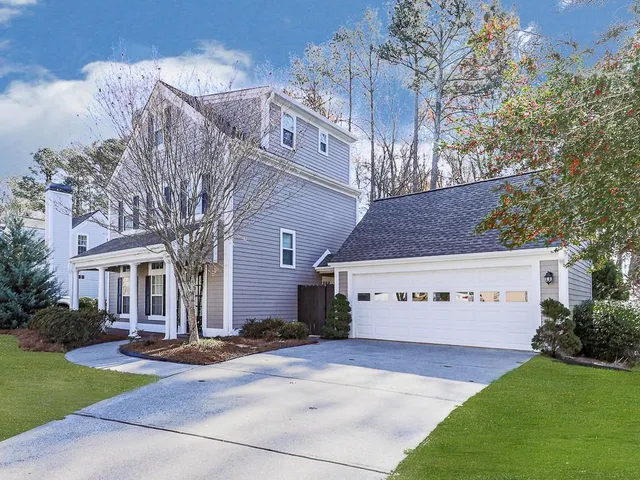 a view of a white house with a yard next to a road