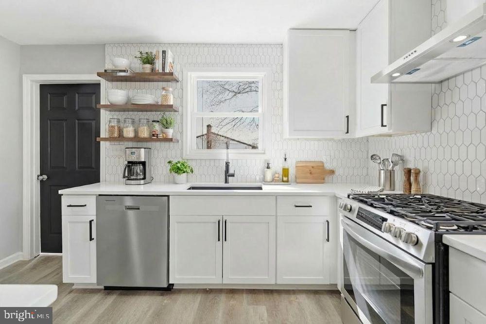 a kitchen with cabinets appliances a sink and a window
