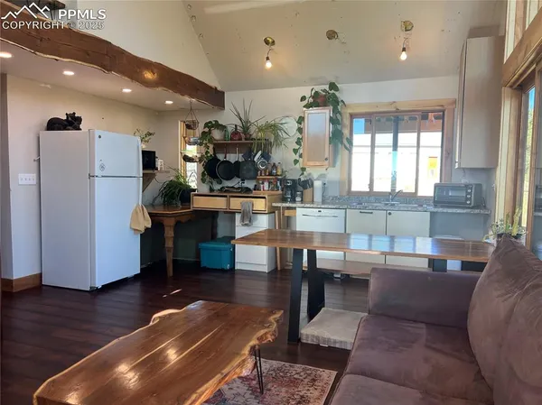 a living room with furniture a wooden floor and a large window