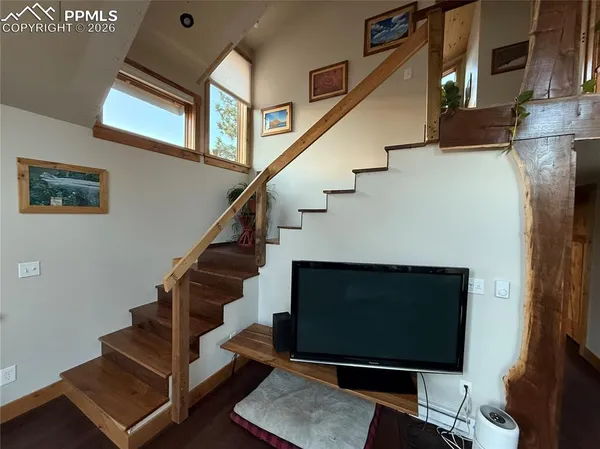 a living room with stairs and a fireplace